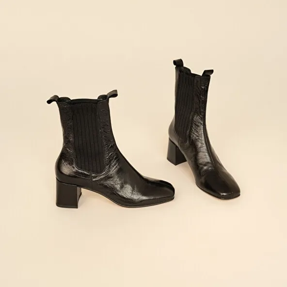 Heeled boots with gathers in black aged leather