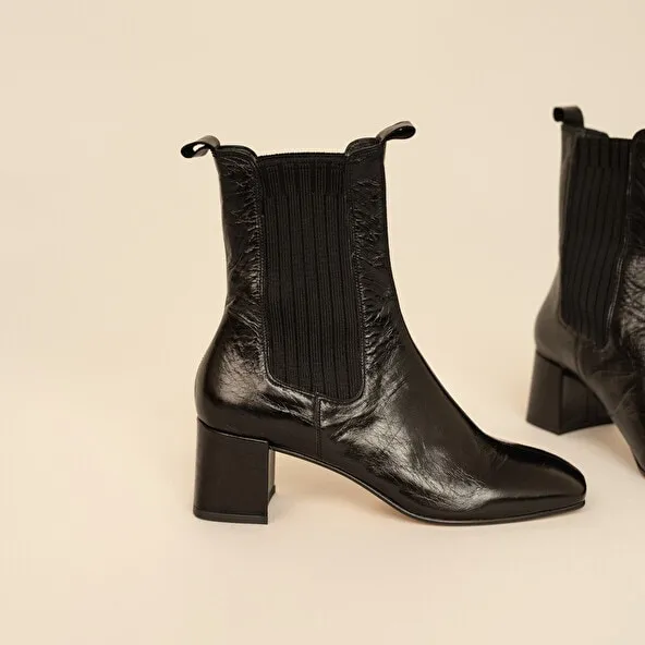 Heeled boots with gathers in black aged leather