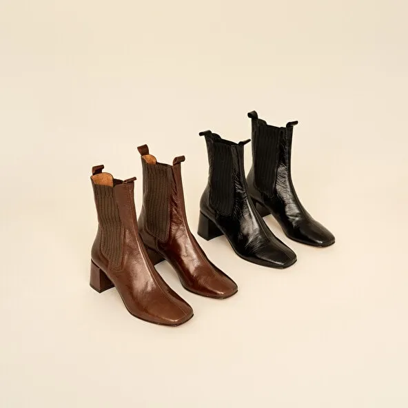 Heeled boots with gathers in black aged leather